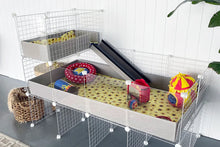 Load image into Gallery viewer, A grey Ozzy Cages C&amp;C Guinea Pig enclosure with 2x1 loft filled with HayPigs! circus accessories. Lifestyle image.
