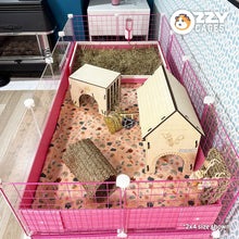 Load image into Gallery viewer, Pink 2x4 Ozzy Cages C&amp;C Guinea Pig Enclosure with clear sides, pink grids, a stand and storage boxes. Also features an Ozzy Kitchenette litter tray. Shown set up with enrichment toys, tunnels and hides. Also a water bottle with water bottle holder. 
